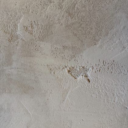 Limewash over render, in raking light