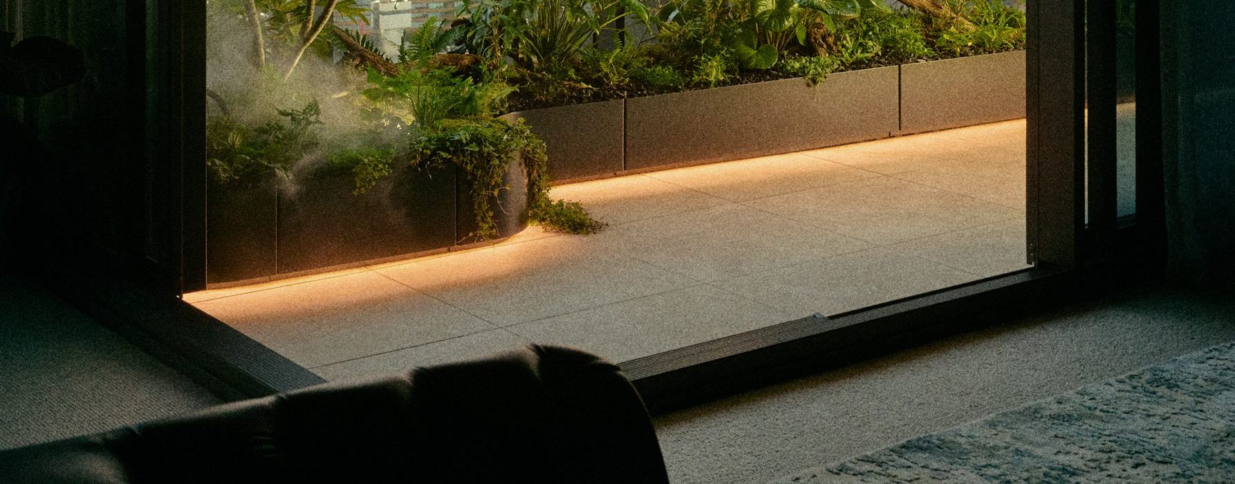 A planted WANN Planter on a city rooftop at dusk