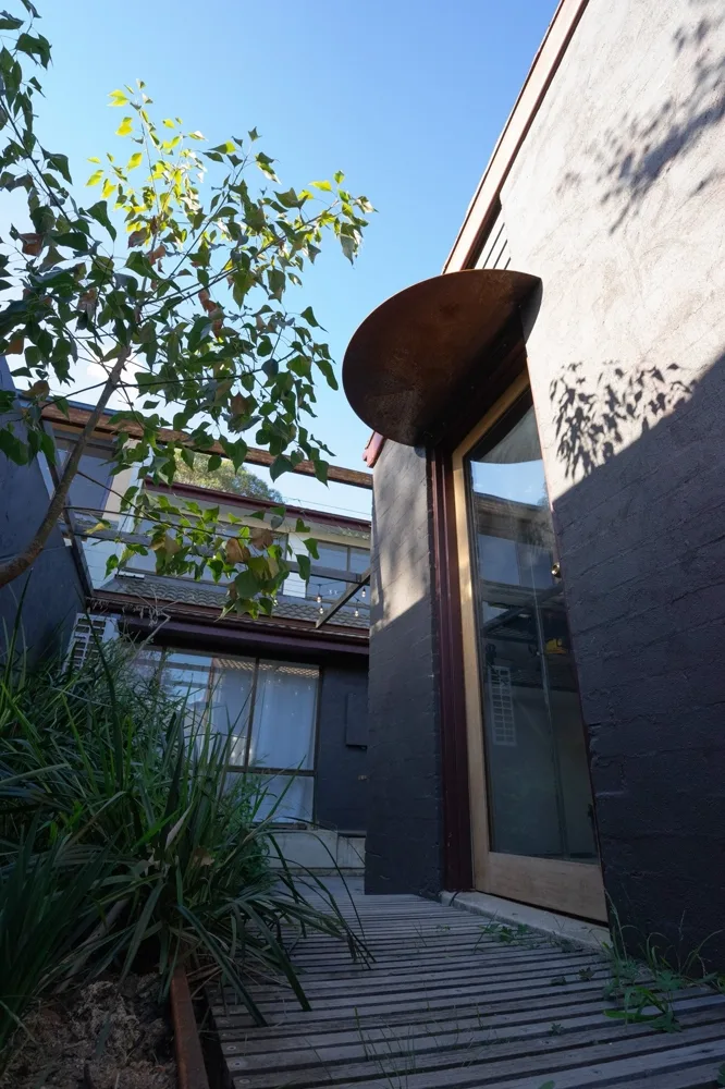 Courtyard with corten steel, dark render and wild planting
