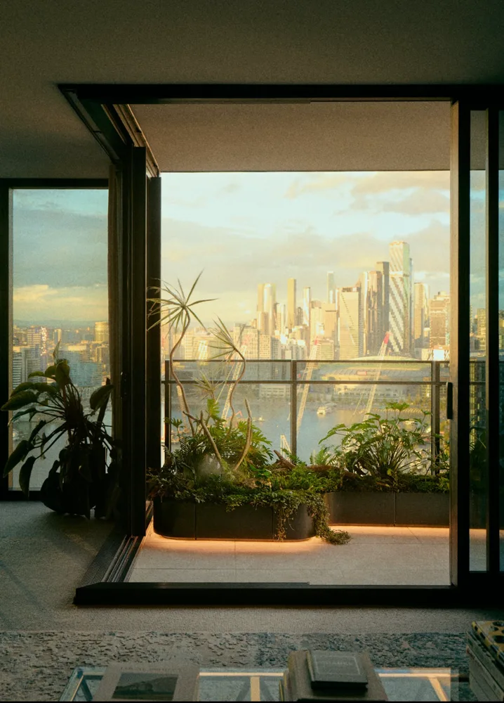 Apartment interior looking out to a planted balcony and skyline