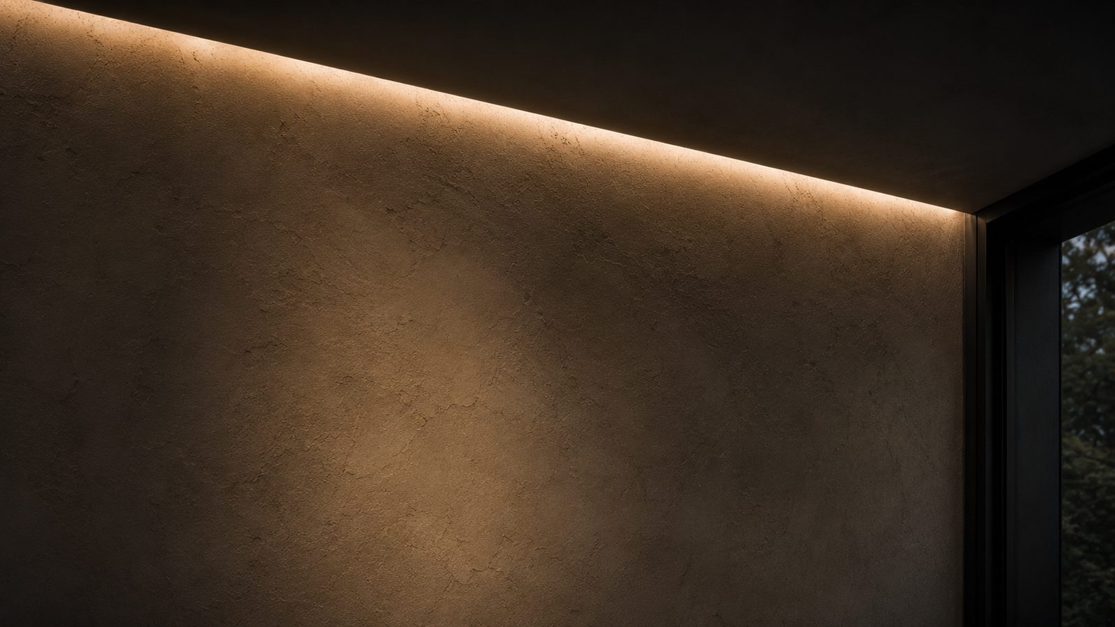 Cove light at the junction of wall and ceiling, beside a dark window frame
