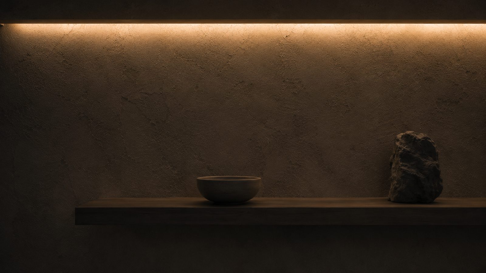 Warm concealed strip lighting above a timber shelf